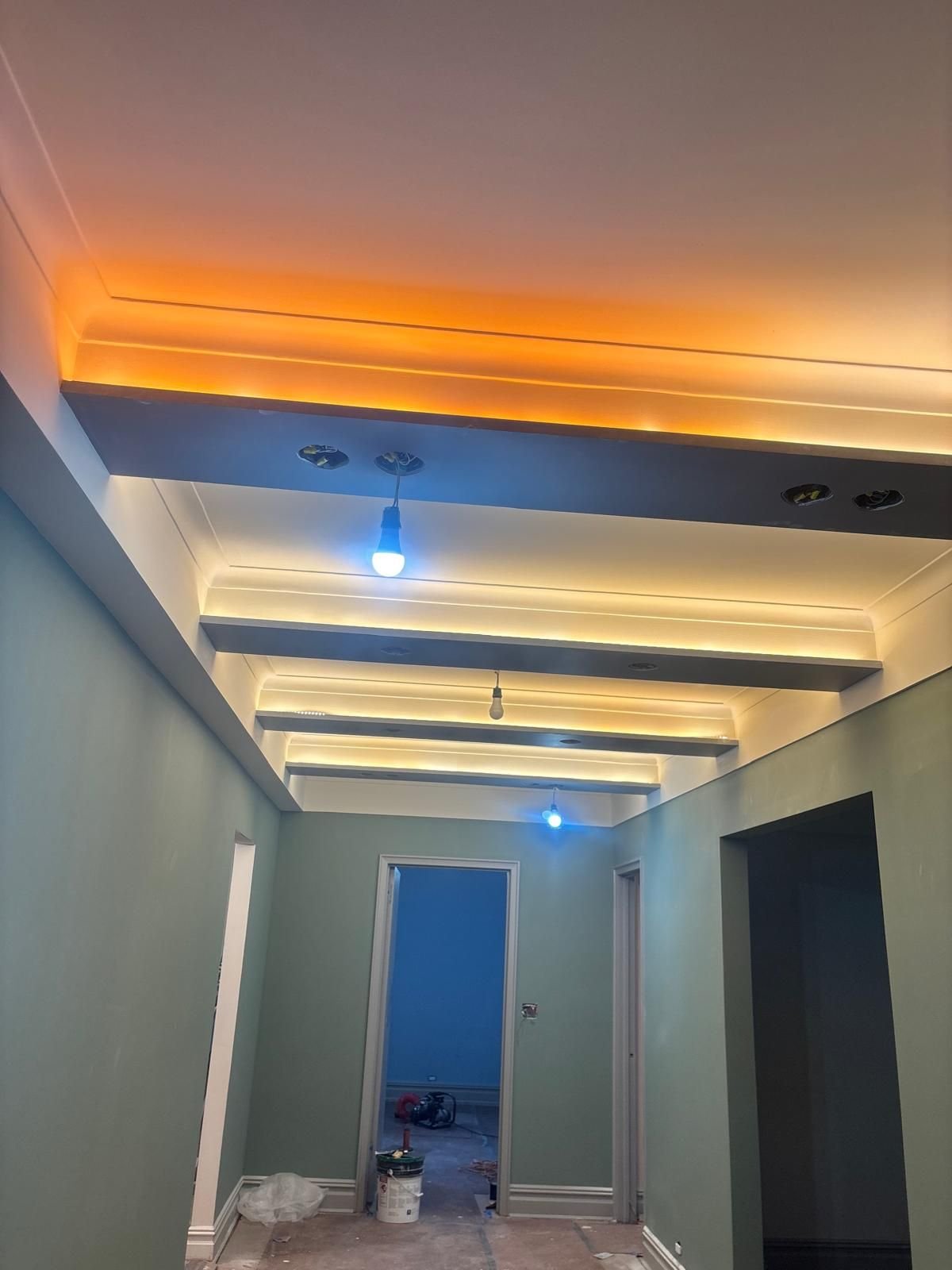 Sage hallway with painted ceiling beams and cove lighting
