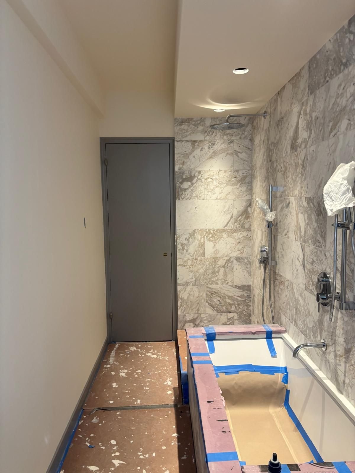 Tub and tile masked before painting a marble bathroom