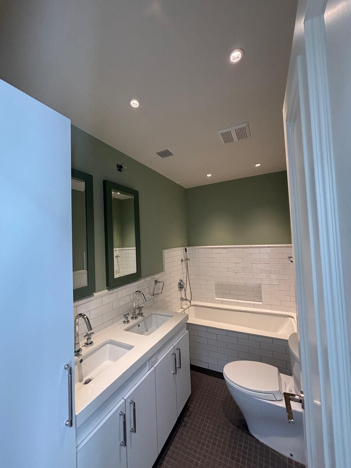 Sage green bathroom with crisp white trim