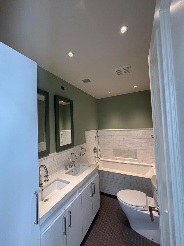 Sage green bathroom with crisp white trim